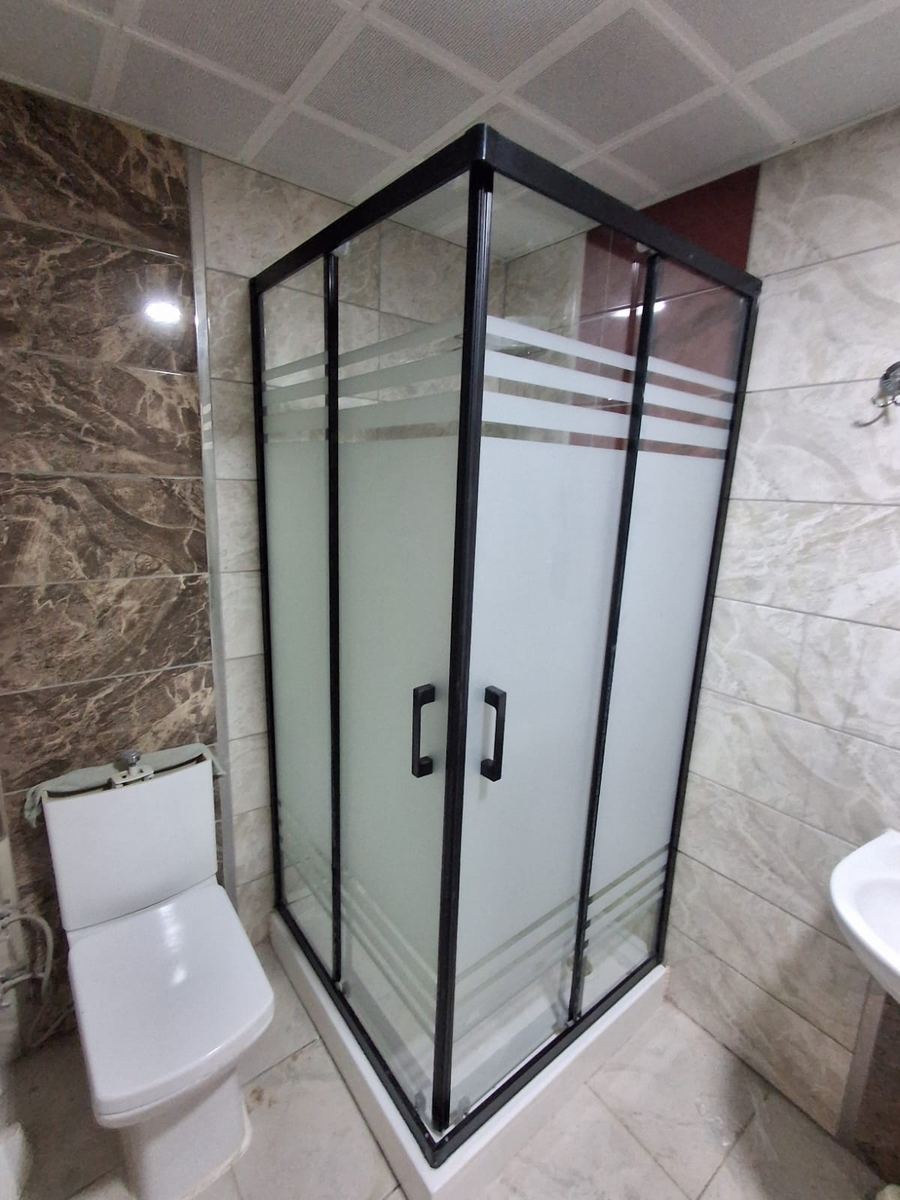 Banyoda siyah çerçeveli köşe duşakabin