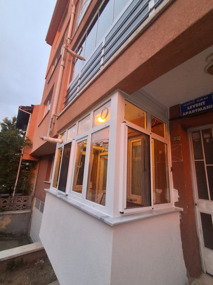 Turuncu cepheli binada beyaz kapatılmış cumba balkon
