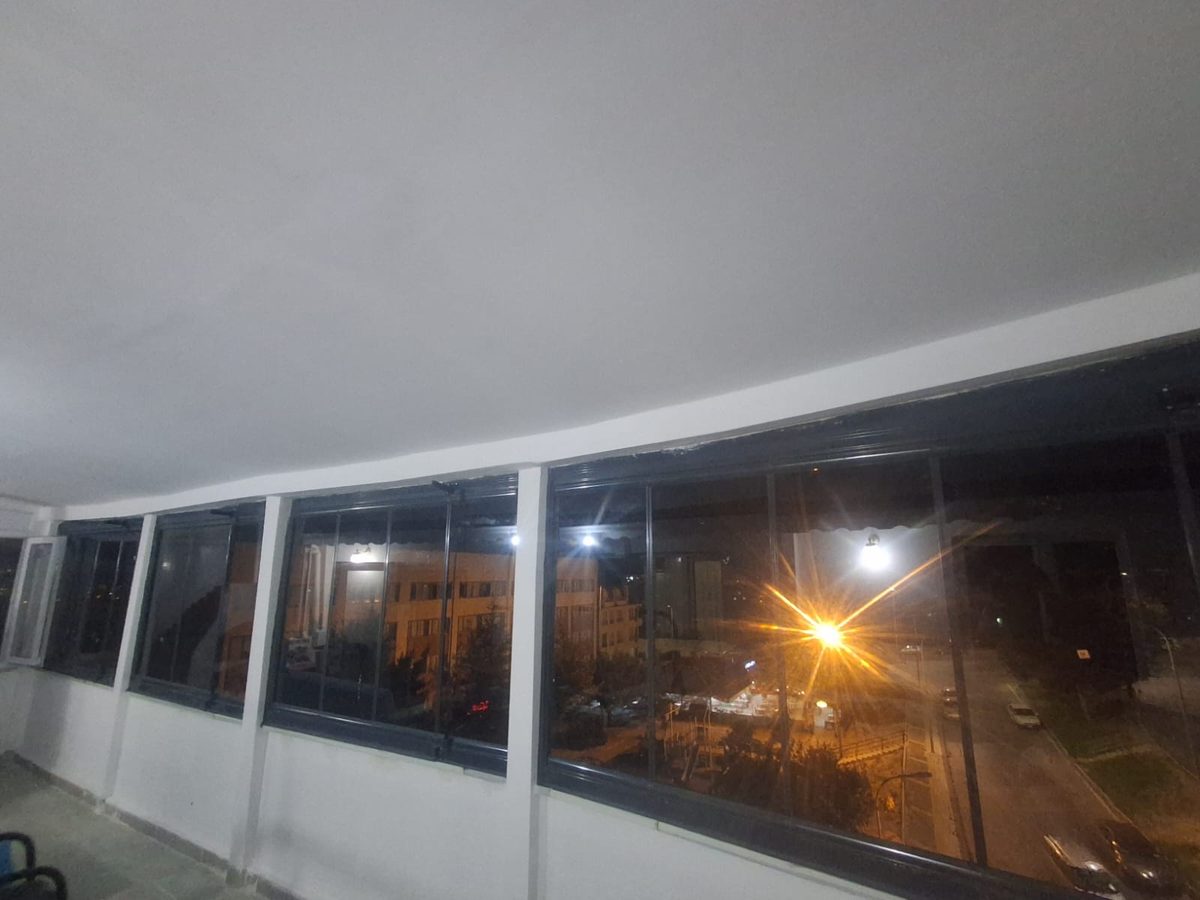 Gece saatinde içeriden bakılan cam cepheli kapalı balkon